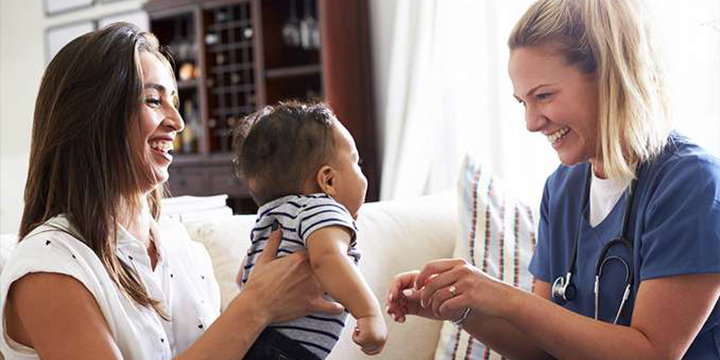 A mother passes her baby to a doctor